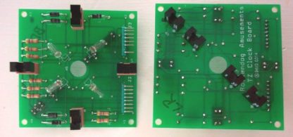 Two green boards with electronic components on top of them.