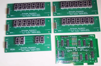 A set of six electronic displays on top of a green board.