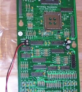 A green board with wires and buttons on it