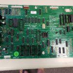 A green circuit board sitting on top of a table.